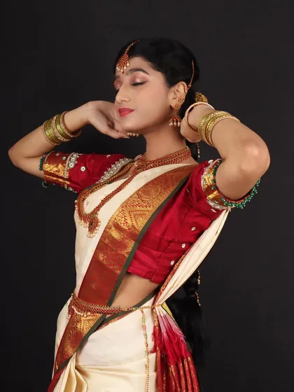 A graceful pose from a Murtham bride shoot. The makeup is kept soft and nude to complement the classic white and red silk saree.