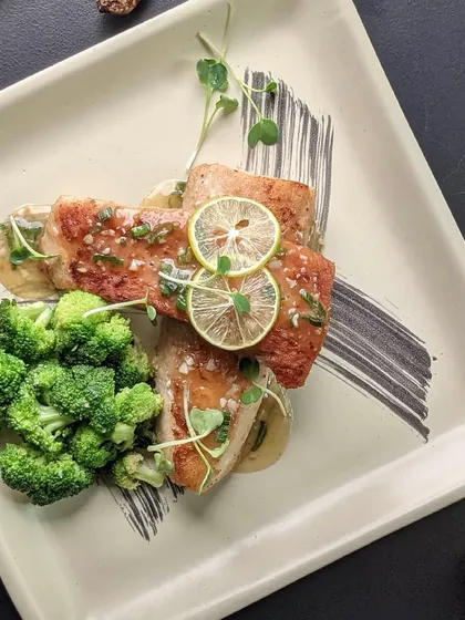 A fusion of bold spices and savory ingredients. This beautifully plated fish dish with lemon and broccoli showcases our modern approach to Pan-Asian cuisine.