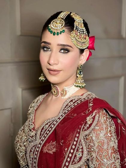 A close-up of a bride with dramatic smokey eyes, paired with a traditional passa and maang tikka.