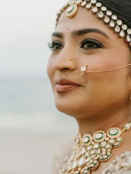 A close-up of the bride's soft, subtle makeup, featuring a delicate nath and kundan jewellery that I provided.