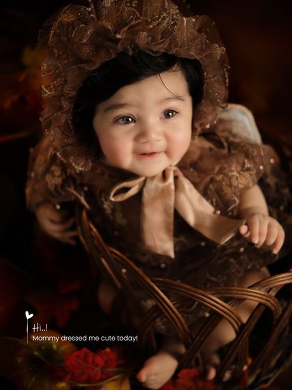 All dressed up in a vintage-style brown lace outfit, this baby is ready for her autumn-themed portrait session in a rustic basket.