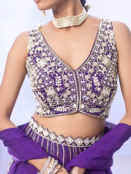 A closer look at the intricate beadwork and metallic thread embroidery on our purple lehenga blouse. The craftsmanship is designed to make a statement, blending traditional techniques with a modern colour palette.