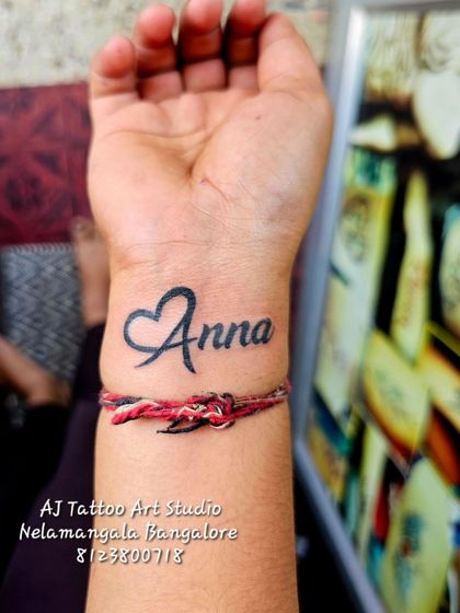 A heart-shaped 'Anna' (brother) tattoo, a great design for sibling bonds.