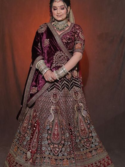 A bride styled in our heavily embroidered wine-colored velvet lehenga. These portraits are a perfect example of a classic bridal look for any MUA's book.
