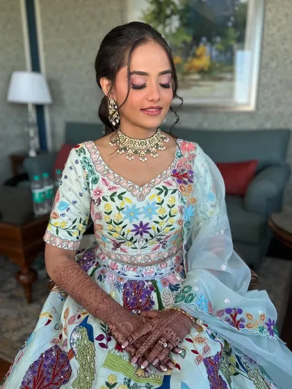 A serene moment for the bride during her Haldi ceremony. The soft makeup and colorful lehenga create a beautiful contrast.