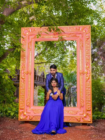 Framing your love story! This creative shot uses a giant ornate frame as a prop, with the couple looking picture-perfect in their formal wear.
