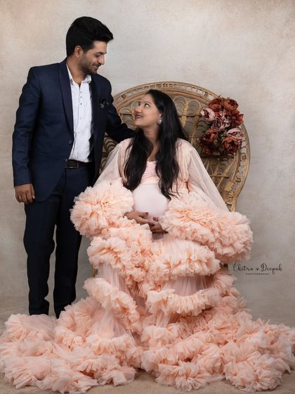 A regal portrait of the expecting couple. She is seated like a queen while he stands by her side, creating a powerful and elegant image.