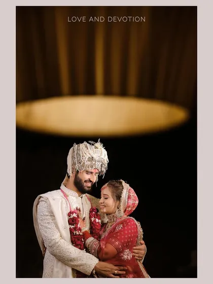 An intimate and artistic wedding portrait. The focus on the couple's loving gaze, framed by the soft glow of a chandelier, creates a moody and deeply romantic image that feels like a scene from a classic film.