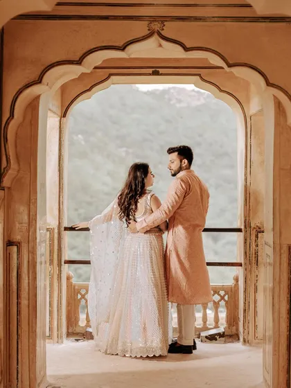 A beautiful composition using the archways of a Jaipur fort to frame the couple. They are looking out at the view together, symbolizing the start of their shared journey.