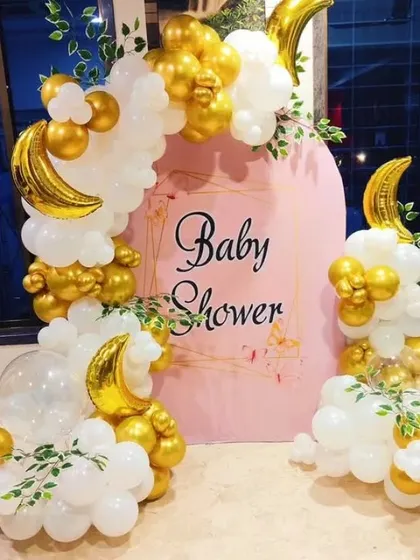 A dreamy "Twinkle Twinkle Little Star" themed baby shower. This setup features a pink backdrop with white and gold balloon clouds and crescent moon foil balloons.