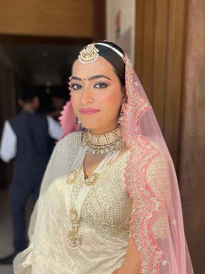 The complete bridal look with the pearl and hydrangea bun, including the dupatta setting. It's a vision in white and pink.