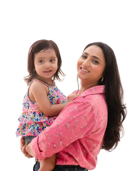 A mother holds her daughter close in this simple, beautiful portrait. The bright, clean background makes their connection and smiles shine.