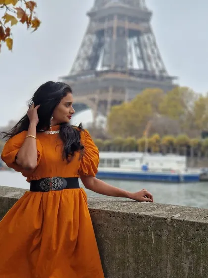 We love seeing our creations travel the world. Here is our wonderful client looking effortlessly chic in our custom orange puff-sleeve dress against the iconic backdrop of the Eiffel Tower in Paris. This is the perfect example of our versatile vacation wear.