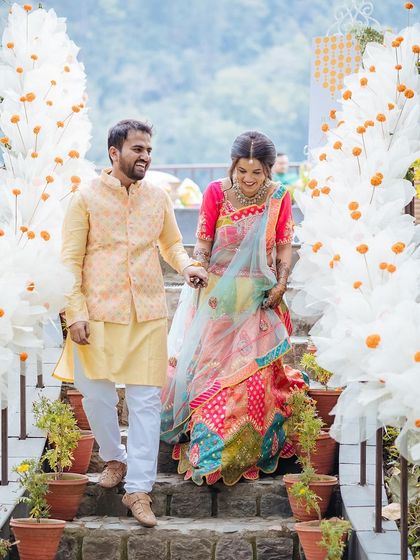 The couple walking hand-in-hand down a staircase adorned with beautiful white floral decorations.