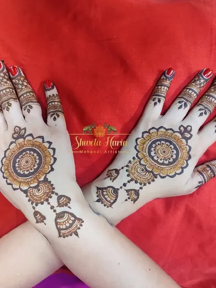Mandalas are an all-time favorite. This classic back-hand design features a large floral mandala with delicate hanging jhumka-style drops, combining two popular and elegant motifs.
