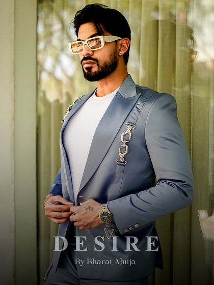 This sky-blue satin blazer is designed for warm weather and high style. The lightweight fabric and unique silver chain detailing make it a cool, comfortable, and effortlessly luxurious statement piece.