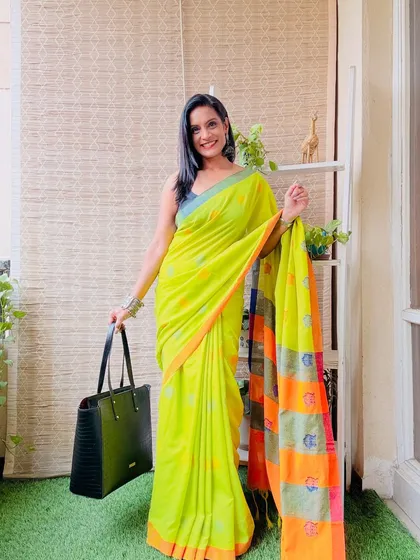 A bright lime green Khadi cotton saree with a contrasting orange and pink pallu. This is a very vibrant and eye-catching saree.