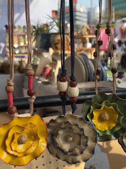 These large, flower-pendant necklaces are statement pieces. Each petal is individually shaped and layered to create a beautiful, blooming effect.