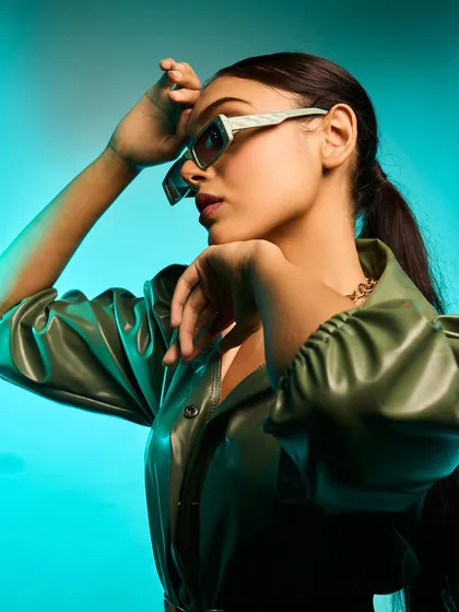 A side profile in the green leather-look dress, highlighting the cool-toned lighting and the texture of the fabric. This is a great example of my work in creative and editorial shoots.