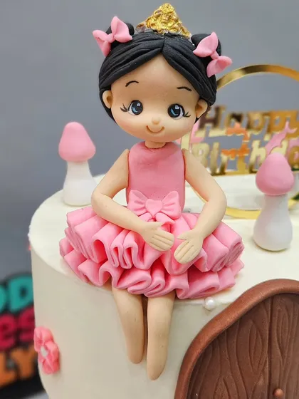 The delicate ballerina figurine sitting atop the floating cake tier. Every element, from the ruffled dress to the tiny crown, is crafted by hand to complete the story.