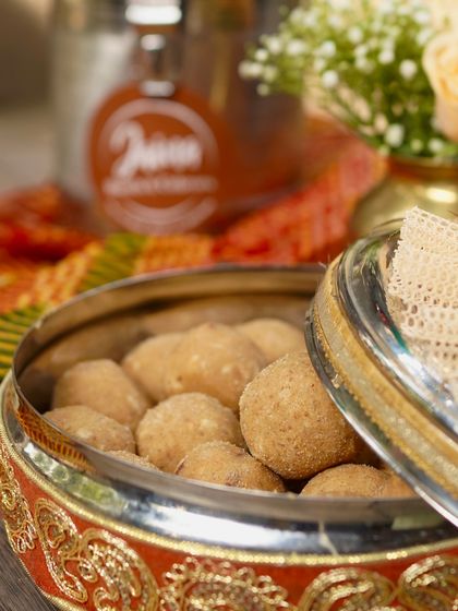 A beautifully decorated container filled with our homemade Atta Laddoos. These are a staple in every household during Delhi winters for their warmth and nutrition.