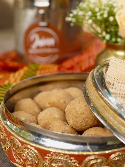 Our Atta Laddoos, packed in a traditional container. These are not just sweets, they are a warm hug on a cold day.