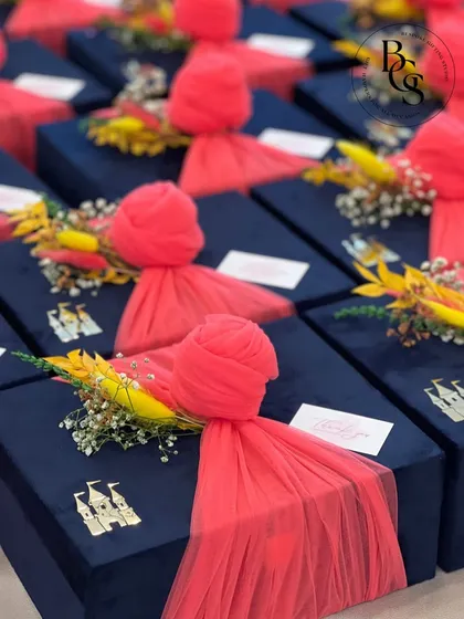 A collection of navy blue velvet boxes adorned with vibrant pink tulle and a custom castle charm. This combination of rich color and texture creates a fairytale-like feel, perfect for a themed event or special celebration.