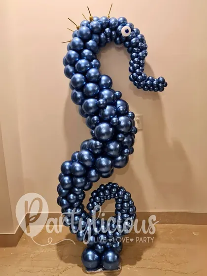 A seahorse sculpture crafted from hundreds of metallic blue balloons. The detailed twisting and shaping create a stunning, shimmering effect, perfect for an ocean-themed or luxury event.