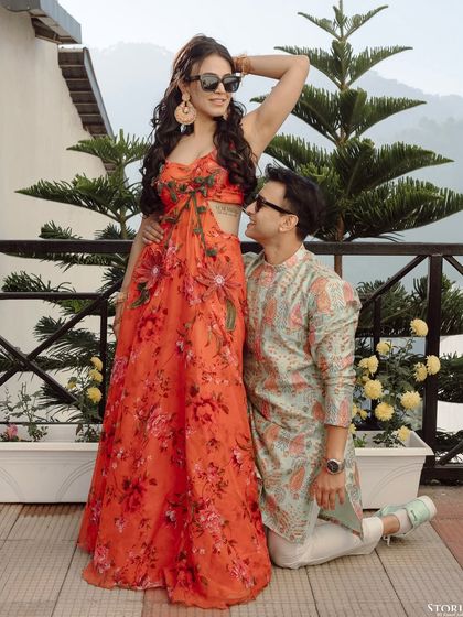 A fun and quirky pose with the groom kneeling, looking up at his bride, capturing their playful dynamic.