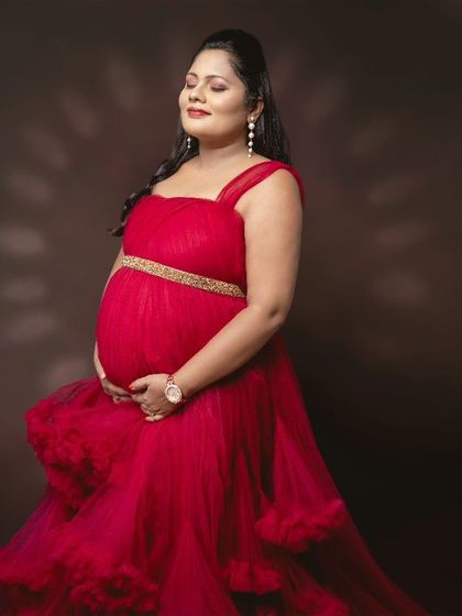 Capturing the purest bond before the world meets this little miracle. A serene portrait in a vibrant red tulle gown.