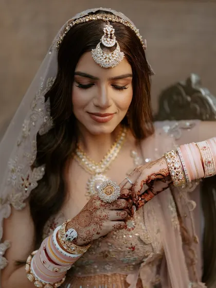 A close-up on the details. The soft makeup look is paired with a beautiful matha patti and delicate pink chooda.