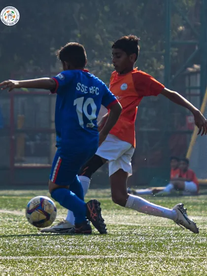 A player shields the ball from a defender, showcasing the physical strength and game sense we develop.