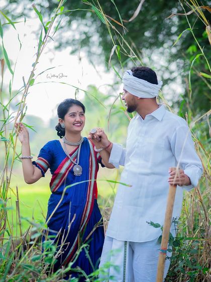 Walking hand-in-hand through tall grass, this shot has a beautiful, natural feel. The traditional Shetkari outfits stand out against the lush green surroundings.
