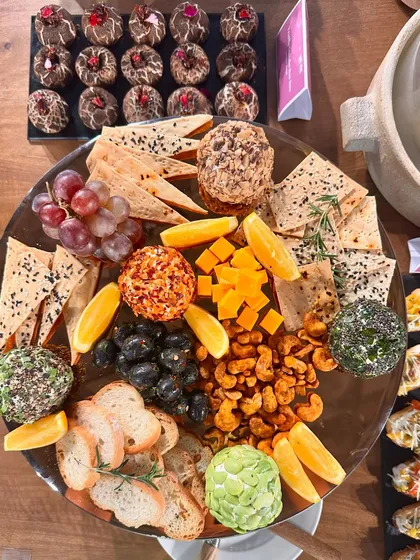 A close-up of the cheese and cracker board, featuring artisanal cheese balls, nuts, fruits, and our signature Truffle Shiitake Bao Buns.