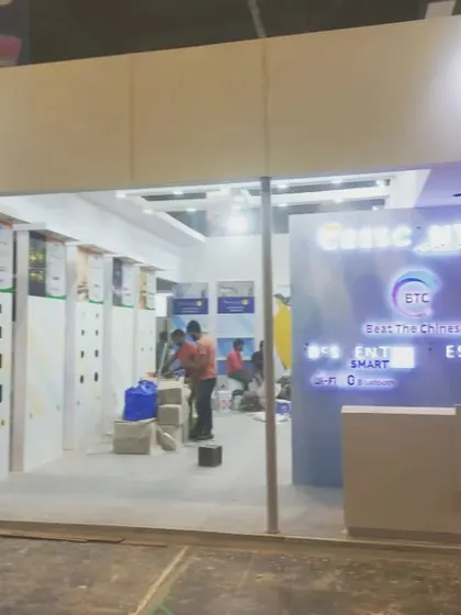 Workers put the finishing touches on the "Beat The Chinese" (BTC) booth, preparing for the show opening.