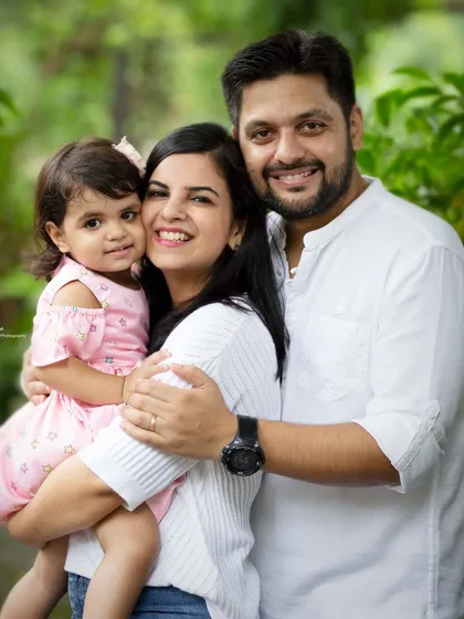 A classic family hug against a lush green background. This portrait shows the warm and loving connection of this beautiful family during their outdoor session.