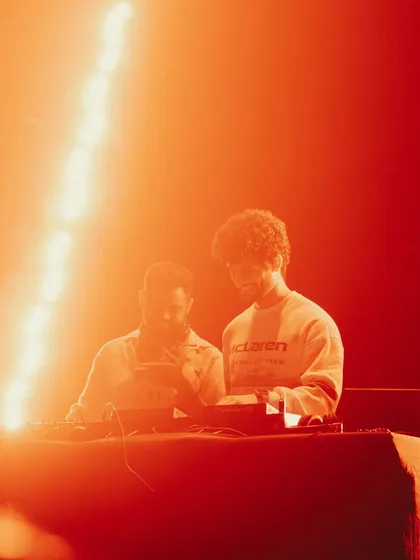 A warm, orange-lit shot of me and Kayvee during our B2B set at Mumbai Famous Studios.