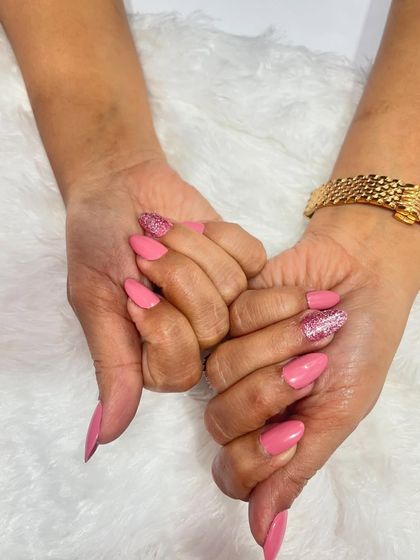 This photo shows the beautiful contrast between the solid pink nails and the full-coverage glitter nail. It's a classic combination that always looks great.