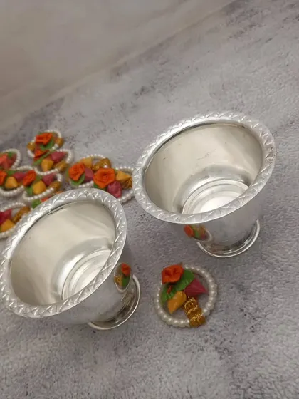 A pair of small German silver bowls with a twisted-rope design rim, perfect for holding chandan and kumkum.