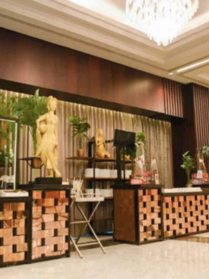 A wide view of a buffet line incorporating elegant statues and wooden textures. We design our catering spaces to be visually engaging and to align with the overall theme of your corporate or private event.