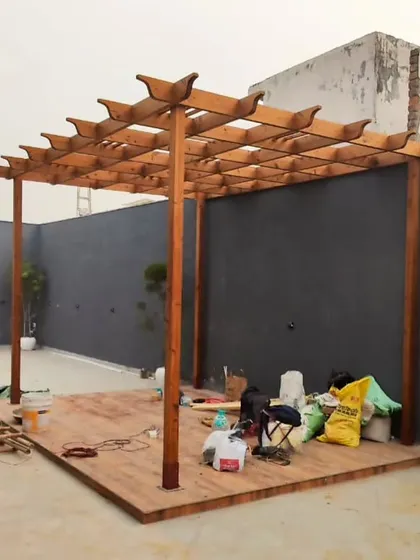 A wooden pergola under construction. This image shows the strong frame and classic design before the finishing touches are added.