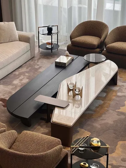 Let's take a moment to acknowledge this beauty. A set of two elongated, low-profile coffee tables, one in dark wood and the other in a light-veined marble, designed to overlap and create a dynamic centerpiece.