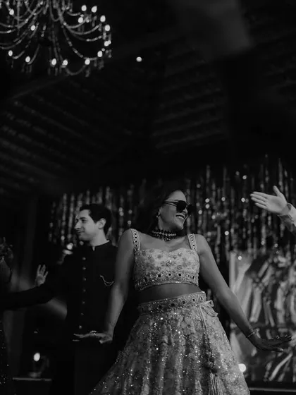 A cool, black and white shot of the bride owning the dance floor with sunglasses on. It's all about that main character energy.
