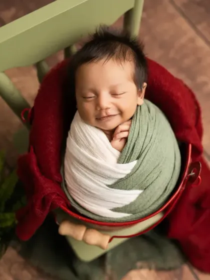 That sweet, sleepy smile is pure magic. Here, I used earthy green and white wraps to create a cozy, natural feel, highlighting the baby's joyful and peaceful expression.