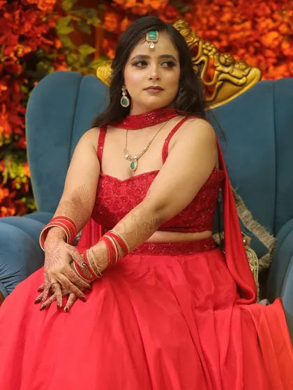 A stunning party look in a vibrant red lehenga. The makeup is kept soft and glowing to balance the bold color.