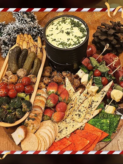 Our Cheese Fondue platter is perfect for cozy holiday gatherings. We serve the warm, creamy cheese fondue with a festive spread of dippables, including bread, crackers, roasted vegetables, and strawberries.