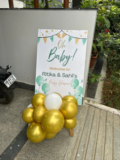 A simple and modern welcome sign for a baby shower, with a clean design and a small balloon cluster.