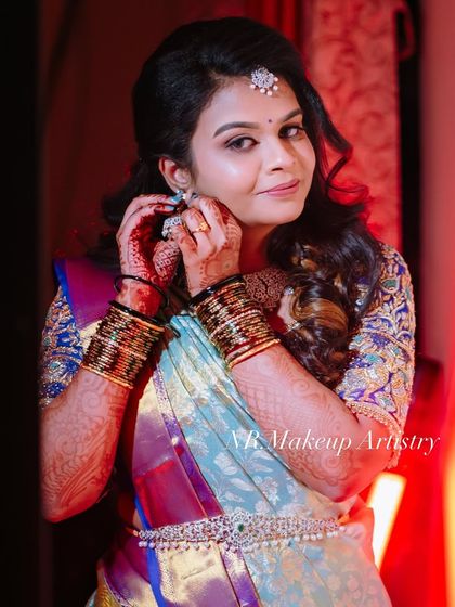 A candid shot of a bride getting ready for her reception. The makeup is soft and shimmery, perfect for an evening event.