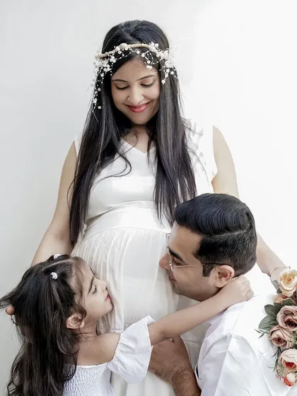 A heartwarming maternity photo with the whole family. The older sibling and father share a tender moment with the mother and her baby bump, celebrating the new life on the way.