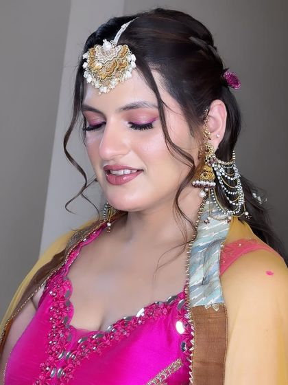 A close-up of Muskan's Haldi makeup. The soft pink eyeshadow and glowing skin enhance her features without competing with her colorful outfit.